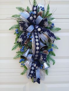 a blue and silver christmas wreath hanging on the side of a white door with snowflakes