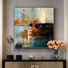 an abstract painting hangs on the wall above a console table with vases and flowers