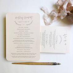 the wedding stationery is laid out next to a brush