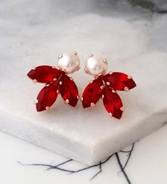 "✤ I can make these earrings with many other colors to match your wedding party scheme (or any other occasion). Please just contact me. ✤ Matching bracelet is available here (TO BE MADE WITH THE RED STONES) https://etsy.me/3bUhUhB ✤ Available also in silver plating, yellow gold plating. Just choose at \"Metal type\" box. ✤ Made with CRYSTALLIZED™ - Swarovski crystals. ✤ Stud/post Earrings. Clip-on earrings are available upon request. ✤ Size approx - 2 x 1.1 cm ✤ Colors: Red ruby, pearl. Rose gol Red Pearl Earrings For Party, Elegant Red Pearl Earrings For Parties, Red Pearl Drop Earrings For Wedding, Red Pearl Drop Earrings For Party, Formal Red Pearl Earrings With Matching Set, Elegant Red Bridal Earrings With Pearl Drop, Elegant Red Jewelry For Bridesmaid Gift, Elegant Red Jewelry For Bridesmaid, Elegant Red Pearl Earrings For Anniversary