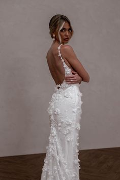 a woman in a white wedding dress with flowers on the back