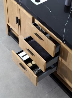 a bathroom vanity with two drawers and a sink in the center, on top of a black countertop