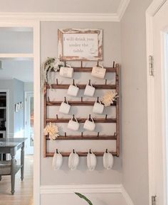 there is a coffee cup rack on the wall with mugs hanging from it's hooks