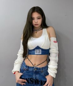 a woman with long hair wearing jeans and a crop top