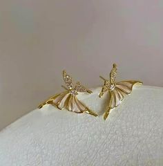 Elevate your style with these stunning butterfly fairy earrings, meticulously crafted for those who love a blend of elegance and fantasy. Featuring gold-plated wings that shimmer in the light, these earrings also boast crystal-studded butterfly wings and soft, mother-of-pearl accents for a luxurious touch. Perfect for special occasions or adding a whimsical flair to your everyday look, these earrings are a true statement piece. Lightweight and comfortable for all-day wear, they make a perfect gi Fairy Earrings, Butterfly Fairy, Pearl Design, Wedding Jewelry Earrings, Butterfly Wings, Wedding Earrings, Love A, Mother Of Pearl, Halloween Shopping