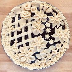 a pie is decorated with flowers and lattices on the top, as if it were made out of fondant