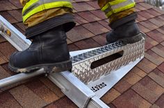 a fireman standing on a ladder to climb up the roof with his boots on