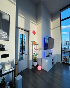 a living room filled with furniture and a flat screen tv on top of a wooden floor