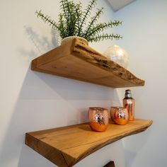 two wooden shelves with vases sitting on top of them next to a planter