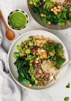 a white bowl filled with greens and chickpeas on top of a marble table