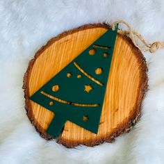 a wooden ornament with a green christmas tree on it