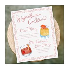 a sign that says signature cocktails next to a glass with an orange slice on it