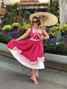 a woman in a pink dress holding an umbrella