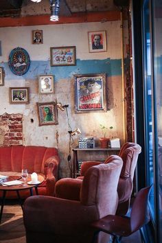 a living room filled with red couches and pictures on the wall next to a window