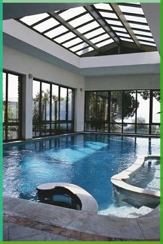 an indoor swimming pool with glass doors leading to the patio and hot tub in the center