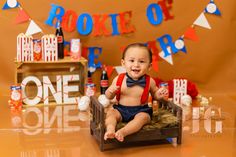 a baby sitting on top of a wooden chair wearing a bow tie and suspenders