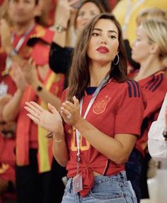 a woman in red shirt and jeans clapping