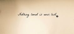 a wall with writing on it that says nothing loved is ever lost in black ink