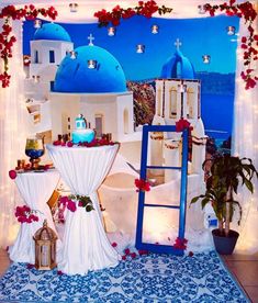 a table with flowers and decorations on it in front of a blue domed building at night