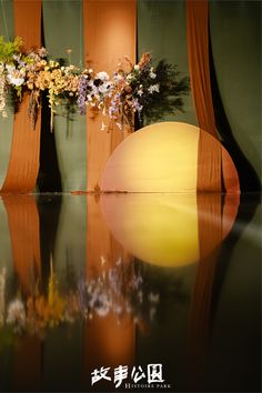 there is a vase with flowers in it on the table next to two tall windows