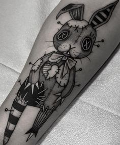 a black and white cat tattoo on the right arm, with an arrow in its mouth