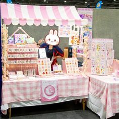 a table with pink and white checkered cloths on it that has a stuffed animal at the top