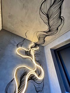 an artistic light painting on the wall next to a doorway with a door and window