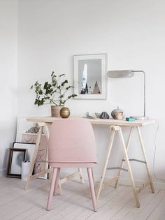 a pink chair sitting next to a wooden desk