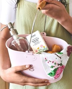 a woman is holding a pink container with various items in it