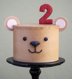 a two year old birthday cake with a bear face on top and the number 2