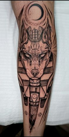 a man's leg with tattoos on it and an image of a wolf in the middle