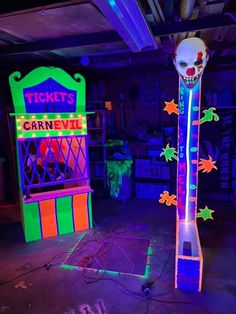 two neon signs and a fake clown's head on display in a dark room