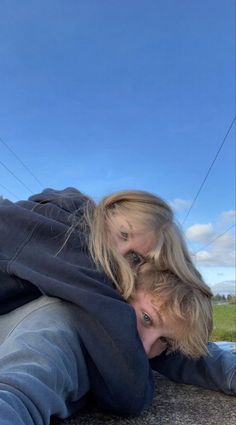 two people are laying on the ground and one is holding his head over another person's shoulder