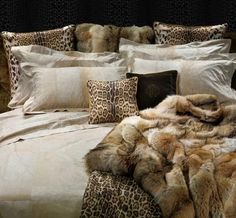 a leopard print bed spread with pillows and blankets