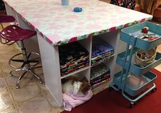 a dog laying on top of a rug under a table with several shelves and chairs