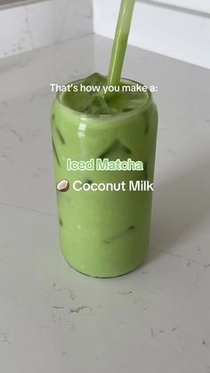 there is a green smoothie with a straw in it