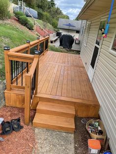 a wooden deck next to a house with shoes on the ground