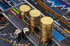 stacks of coins sitting on top of each other in front of a stock market chart