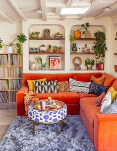 a living room filled with furniture and lots of shelves on the wall above it's headboard