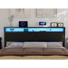 a bed with an illuminated headboard and night lights on the top shelf above it