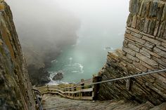 stairs leading down to the ocean on a foggy day