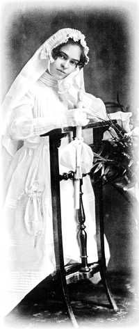 an old black and white photo of a woman in a wedding dress sitting on a chair