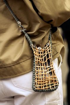 a close up of a person holding a handbag on their back with an attached strap