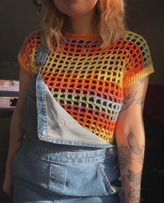 a woman wearing overalls and a crocheted top with an open back design