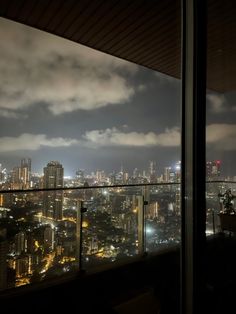 the city lights are lit up at night from an observation deck in a high rise building