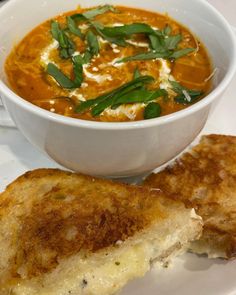 a bowl of soup and two pieces of toast on a plate