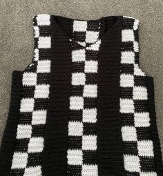 a black and white crocheted sweater with squares on it