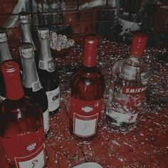 there are many bottles of wine on the table with silver confetti around them