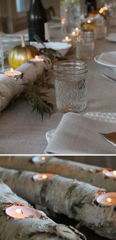 the table is set with white plates and silverware, candles, and glass jars