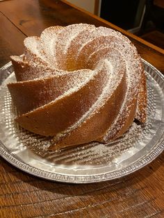 a bundt cake sitting on top of a glass plate covered in powdered sugar